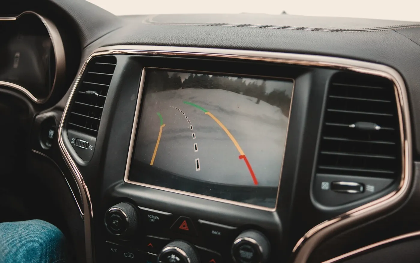 In-dash screen showing a reversing camera view with parking guides