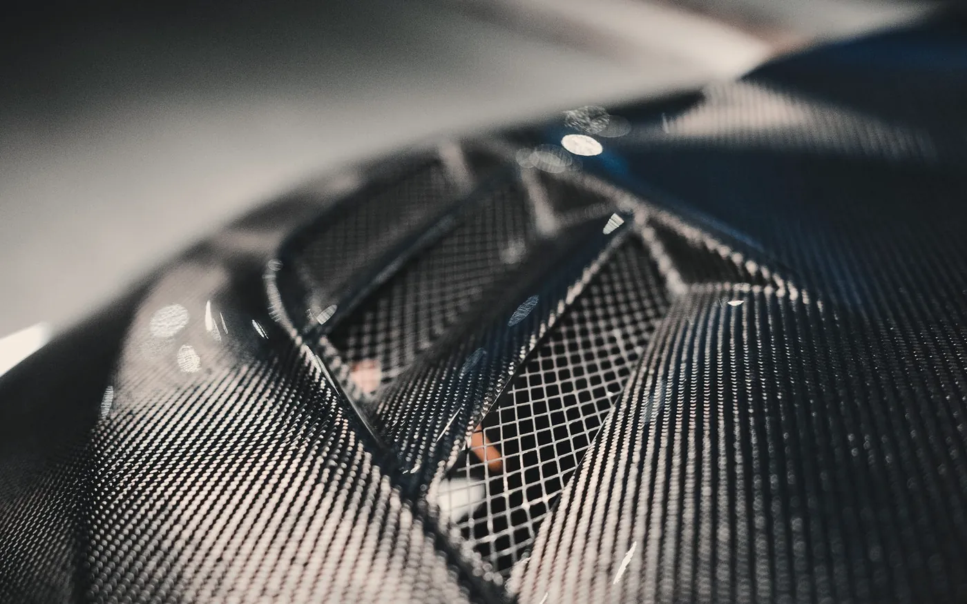 Close-up of a woven carbon-fibre car bonnet with air intakes
