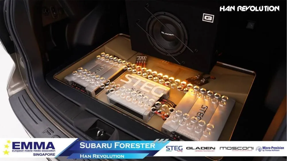 Amplifier and DSP processor rack built into a car boot by Han Revolution, with accent lighting showing the signal chain
