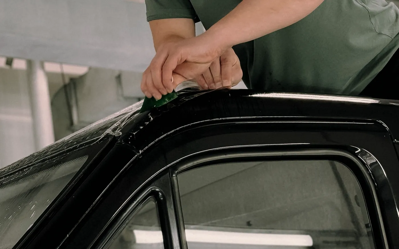 Window tinting film being applied to a car window