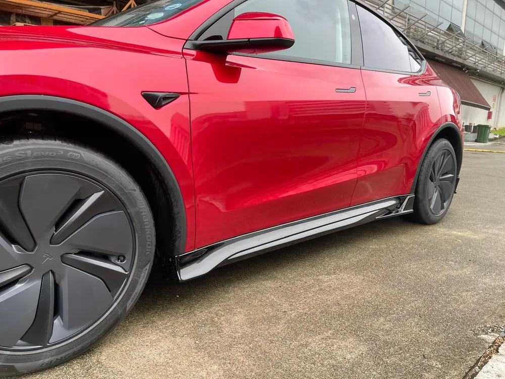 Side skirt detail of the Han Revolution bodykit on a red Model Y Juniper