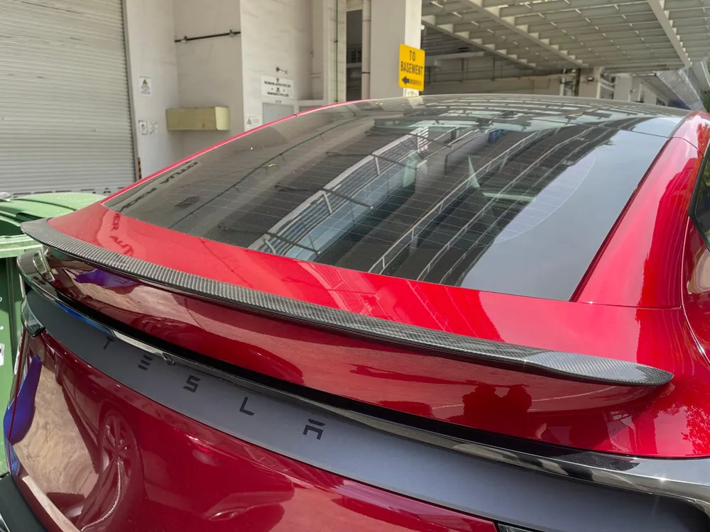Rear view of a red Tesla Model Y Juniper with a Han Revolution carbon fibre boot lip spoiler