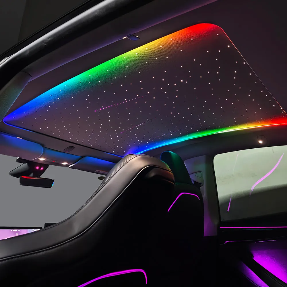 Starlight roof shade fitted to a Tesla, showing the starfield and a rainbow colour sweep with purple ambient lighting in the cabin